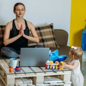 Woman doing yoga in front of laptop.
